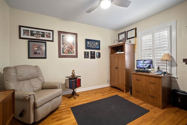 living area with ceiling fan, baseboards, and light wood-style flooring