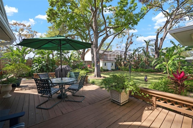 wooden deck featuring a fenced backyard, outdoor dining area, and a yard