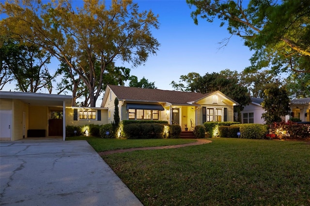 single story home with a carport, concrete driveway, and a front lawn