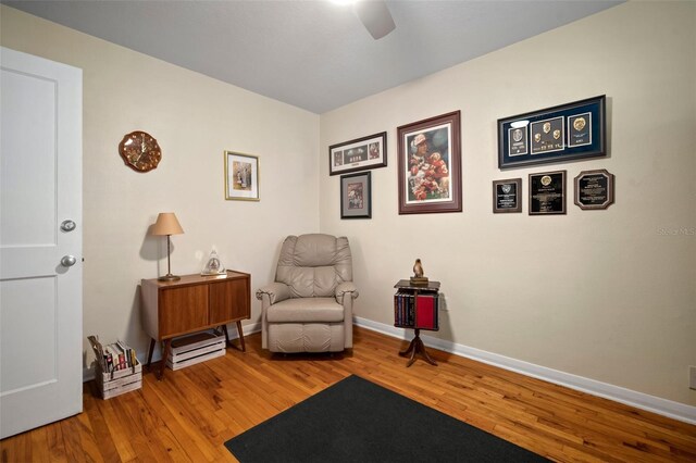 sitting room with baseboards and wood finished floors