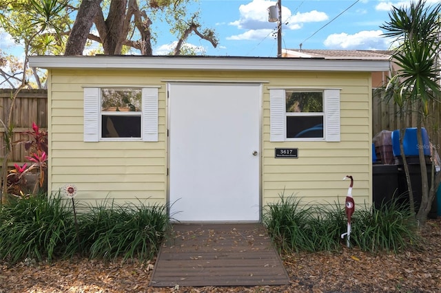 view of outdoor structure featuring an outbuilding and fence