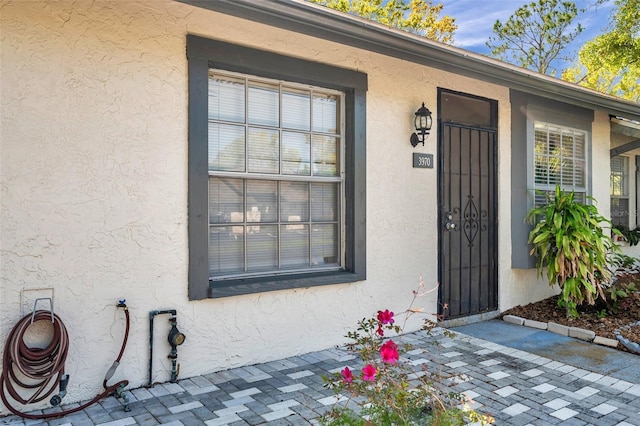 view of exterior entry featuring stucco siding