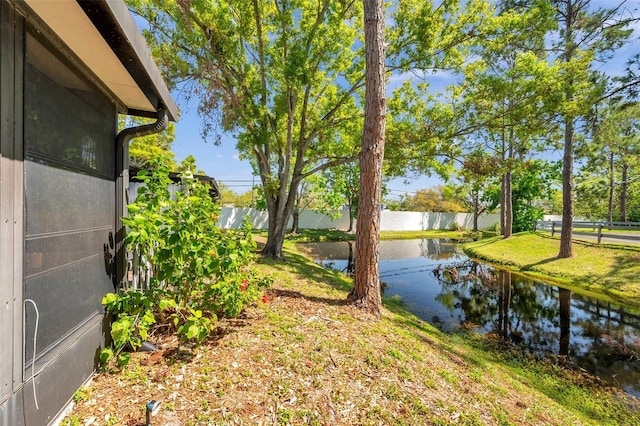 exterior space featuring fence and a water view