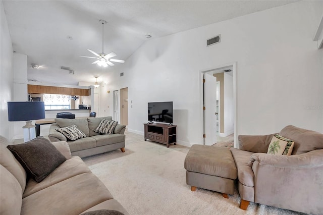 living room featuring baseboards, visible vents, high vaulted ceiling, and a ceiling fan