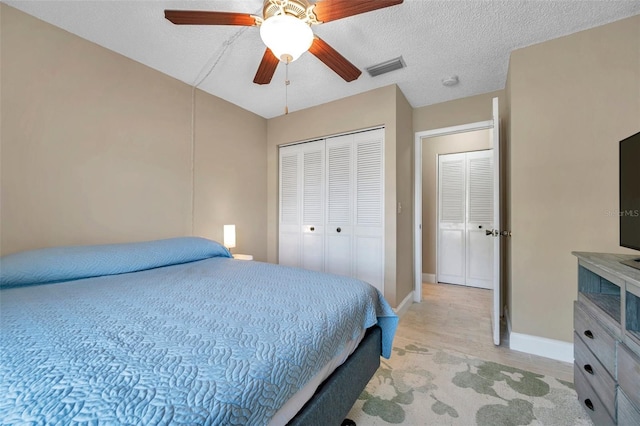 bedroom with a textured ceiling, a closet, light wood-style floors, baseboards, and ceiling fan