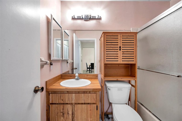 bathroom featuring vanity, toilet, and enclosed tub / shower combo