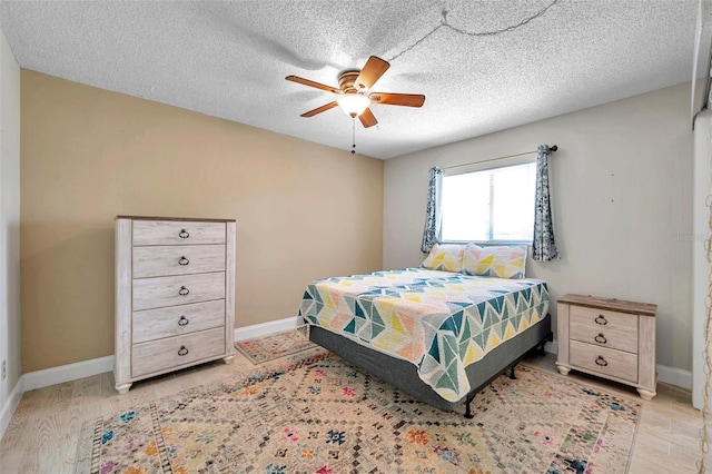 bedroom featuring light wood-style flooring, a ceiling fan, and baseboards