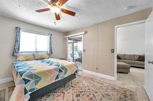 bedroom with access to exterior, multiple windows, baseboards, and wood finished floors