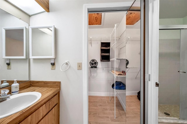 full bathroom featuring a shower stall, vanity, and a walk in closet