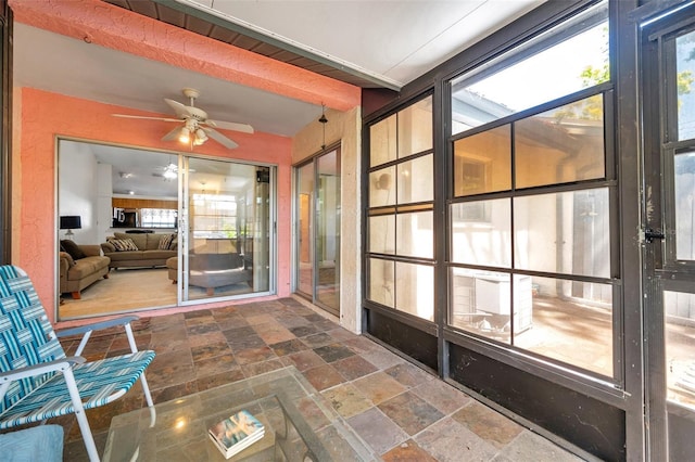 sunroom with a wealth of natural light, beam ceiling, and ceiling fan