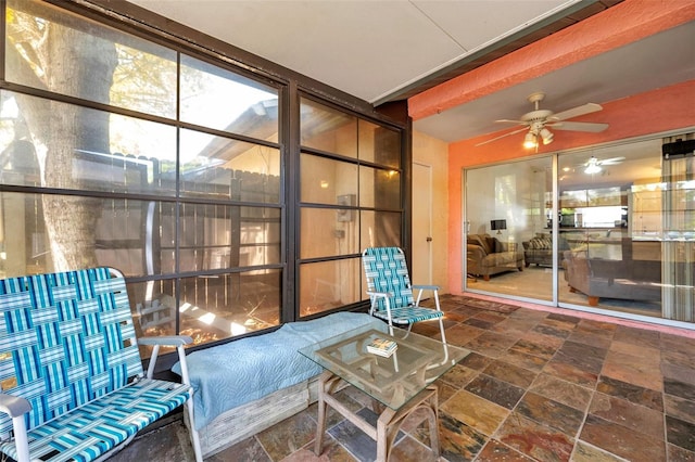 sunroom / solarium with beamed ceiling and a ceiling fan