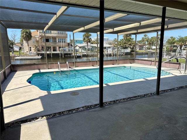 outdoor pool featuring a patio area, a water view, and a boat dock