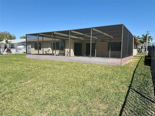 back of house with stucco siding, a lawn, and fence