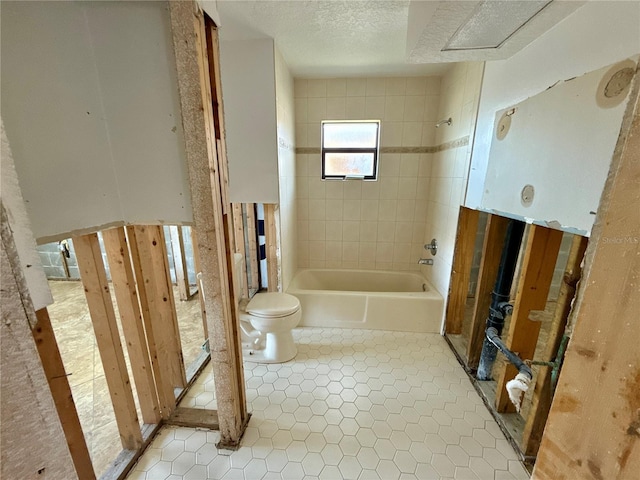 bathroom featuring  shower combination, toilet, tile patterned floors, and a textured ceiling