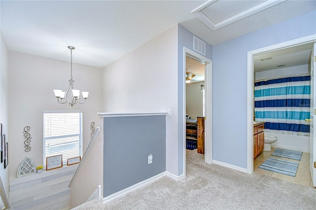 hall with visible vents, an upstairs landing, baseboards, light colored carpet, and a chandelier