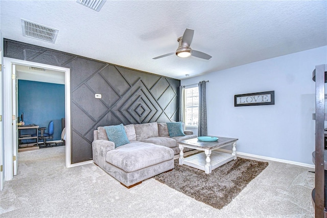 living area featuring visible vents, carpet, and a textured ceiling