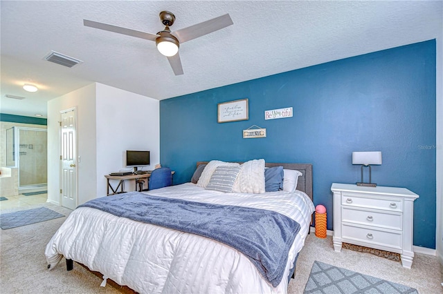 carpeted bedroom with visible vents, ensuite bathroom, a textured ceiling, baseboards, and ceiling fan