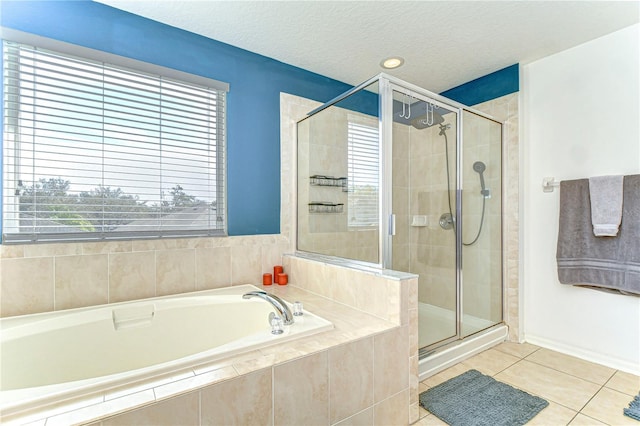 full bathroom with a textured ceiling, a garden tub, a shower stall, and tile patterned flooring