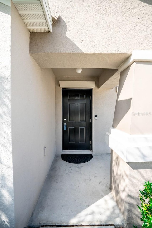 entrance to property featuring stucco siding