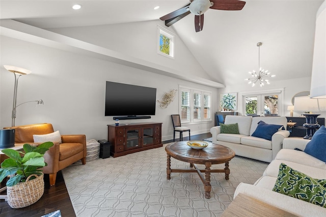 living area featuring high vaulted ceiling, baseboards, ceiling fan with notable chandelier, light wood-style floors, and recessed lighting