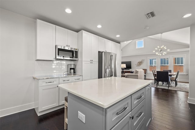 kitchen featuring stainless steel appliances, baseboards, visible vents, and a chandelier