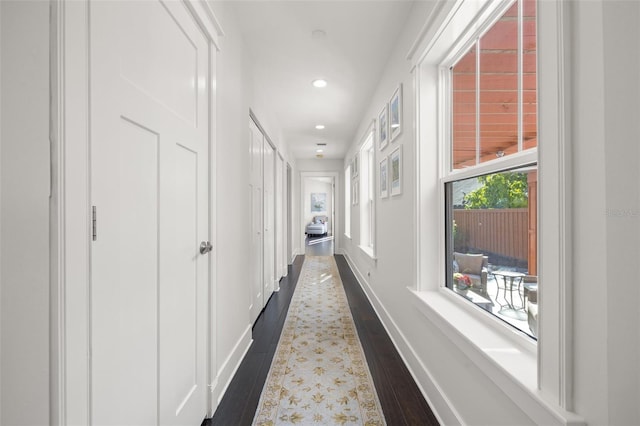 corridor with recessed lighting, baseboards, and dark wood finished floors