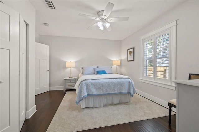 bedroom featuring visible vents, dark wood-style flooring, ceiling fan, and baseboards