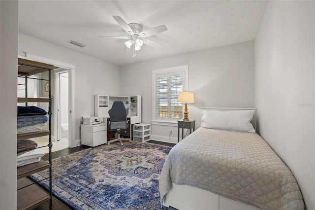 bedroom with baseboards, ceiling fan, wood finished floors, and visible vents