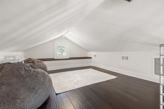 additional living space with baseboards, visible vents, dark wood-style floors, and lofted ceiling