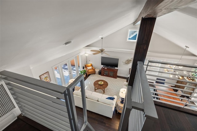 living area with ceiling fan, lofted ceiling with beams, and wood finished floors