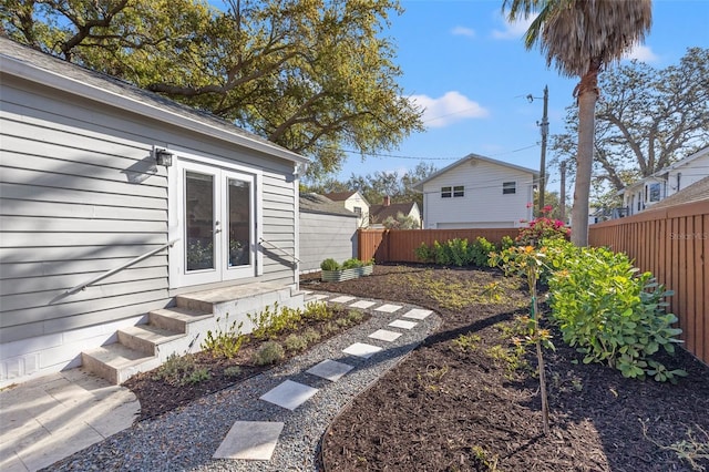 view of yard with french doors and a fenced backyard