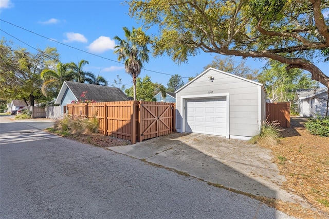 detached garage with fence and concrete driveway