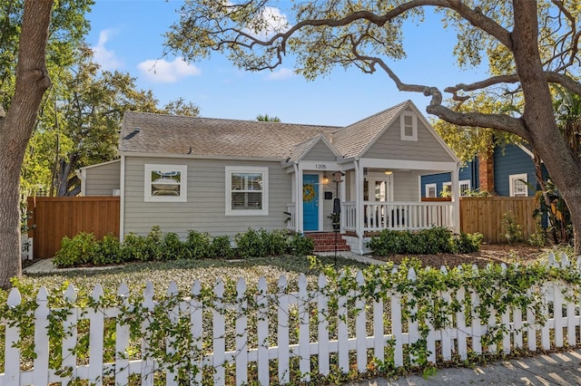 bungalow-style house with covered porch and fence private yard