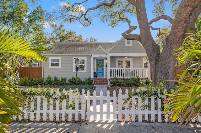 bungalow with covered porch and a fenced front yard