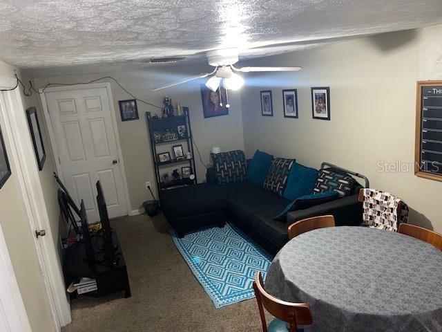 living room with ceiling fan, a textured ceiling, and carpet