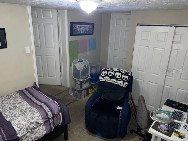 bedroom with a closet, a textured ceiling, and carpet flooring