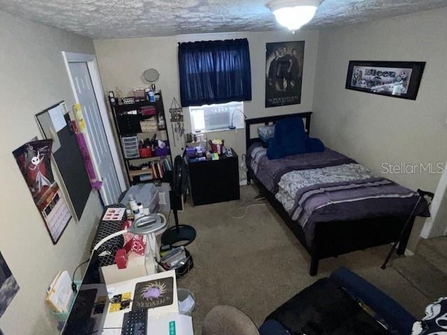 bedroom featuring a textured ceiling and carpet flooring