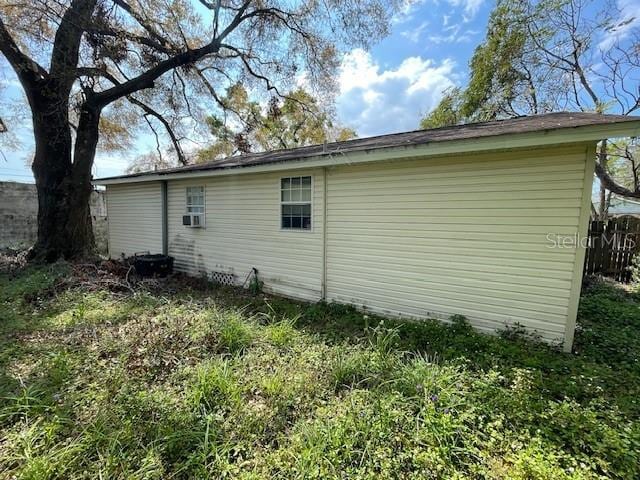 view of home's exterior featuring cooling unit and fence