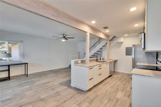 kitchen featuring light wood-type flooring, a sink, stainless steel dishwasher, white microwave, and ceiling fan