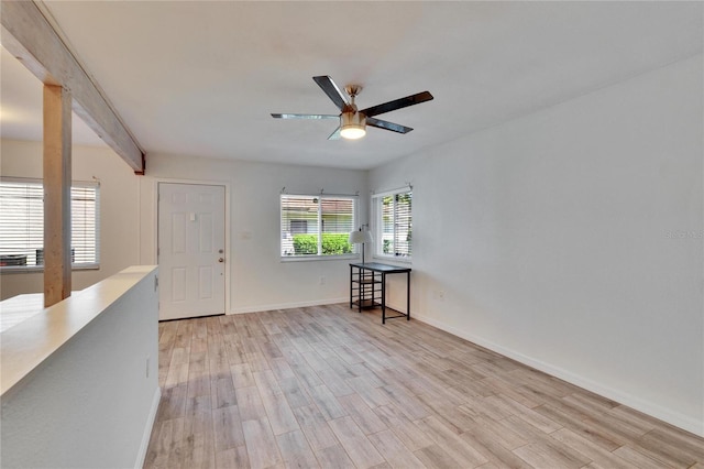 empty room featuring a ceiling fan, baseboards, and light wood finished floors