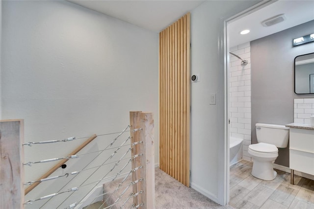 bathroom with shower / washtub combination, toilet, vanity, and baseboards