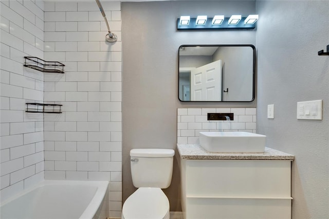 bathroom featuring decorative backsplash, toilet, vanity, and shower / bathing tub combination