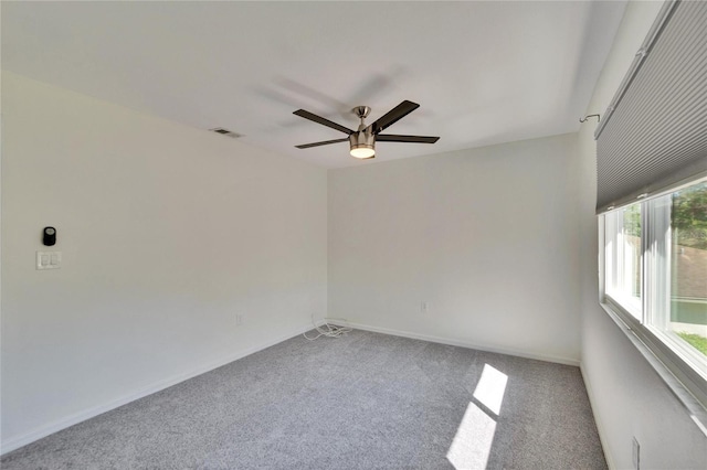 empty room with visible vents, baseboards, ceiling fan, and carpet floors