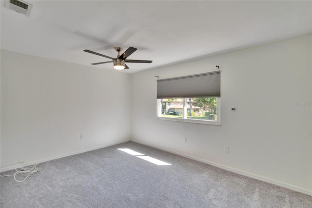 empty room featuring a ceiling fan, carpet, visible vents, and baseboards