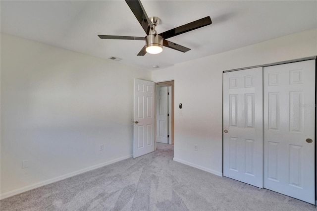 unfurnished bedroom with visible vents, baseboards, light carpet, a closet, and a ceiling fan