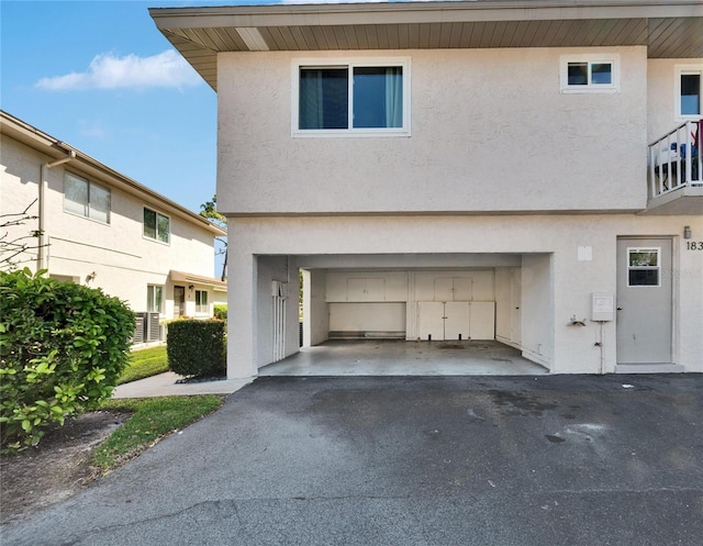 exterior space featuring stucco siding, an attached garage, and driveway