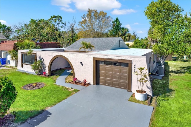 view of front of house with stucco siding, an attached garage, concrete driveway, and a front lawn