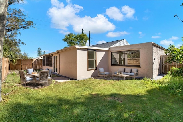 back of house with a yard, stucco siding, an outdoor hangout area, and a fenced backyard