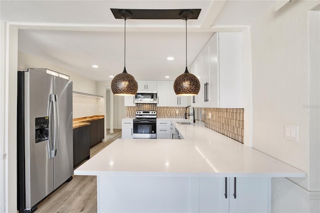 kitchen with light wood-style flooring, a sink, decorative backsplash, light countertops, and stainless steel appliances