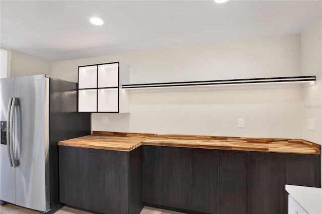 kitchen with recessed lighting, stainless steel fridge, and butcher block counters